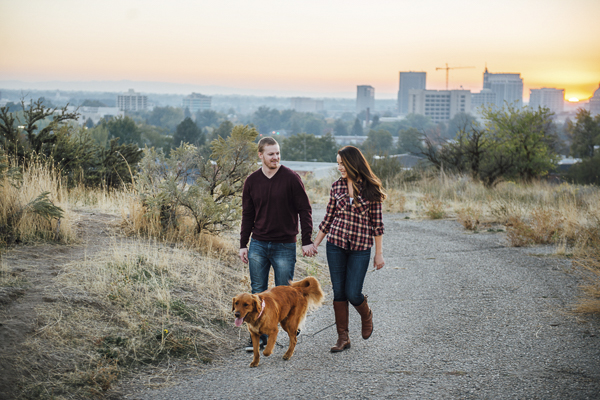engagement photos with Golden Retriever, couple walking dog up hill away from city