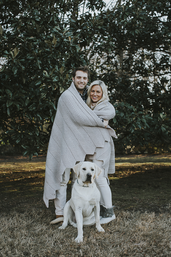 engaged couple wrapped in blanket, English Lab sitting in front of them