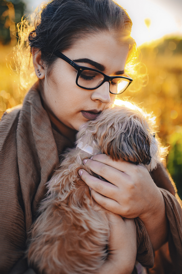 young woman holding small dog, MN on location dog photography