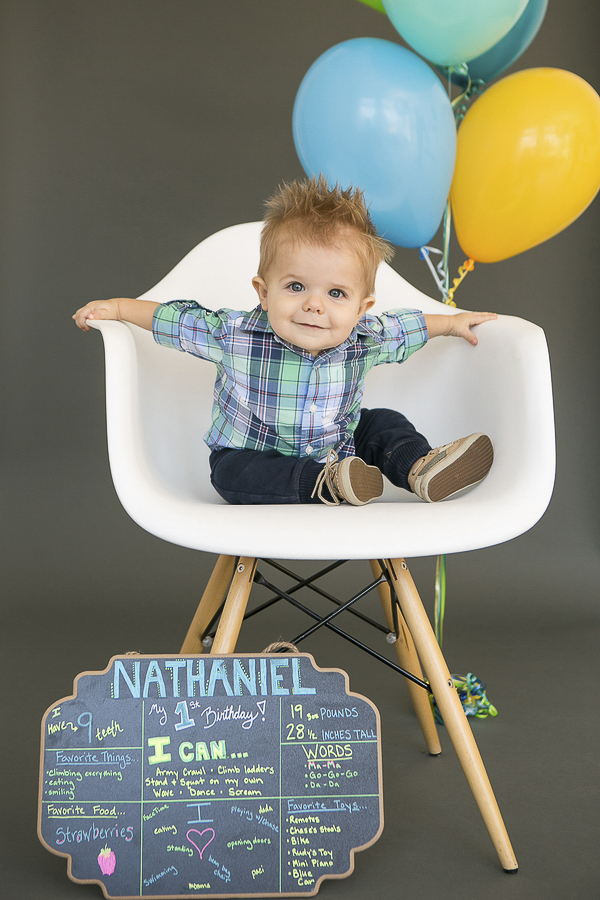 birthday boy with chalkboard sign and balloons, first birthday celebration