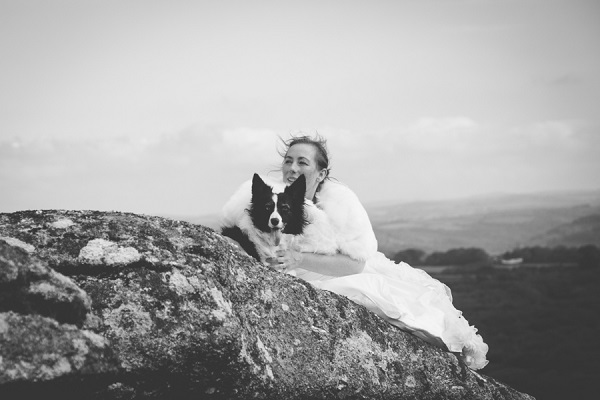 bride and her dog on rock outcrop, after the wedding photos with dogs