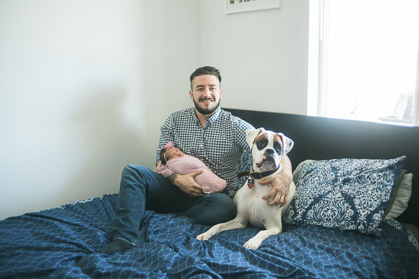 new dad, baby and dog on bed ©Memory Layne Photography | newborn photos with dogs