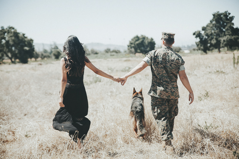 couple holding hands following dog through the field, dog-friendly family photo session | ©Wanderlust Photography