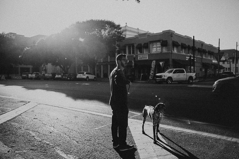 man and his dog in quaint downtown area | ©Joshua and Parisa | Austin Wedding Photographer and Videographer