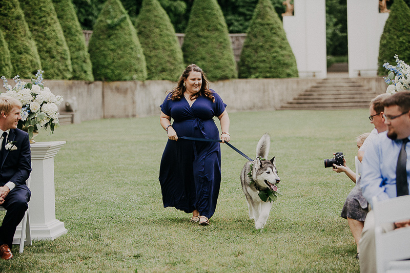 woman in navy dress walking dog in wedding, ideas to include dogs in weddings | ©McKenzie Bigliazzi Photography