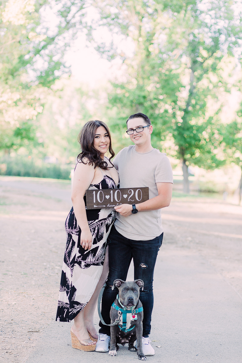 couple holding save the date sign, engagement photos with a pit bull | ©Fig + Willow Studios, Las Vegas, NV