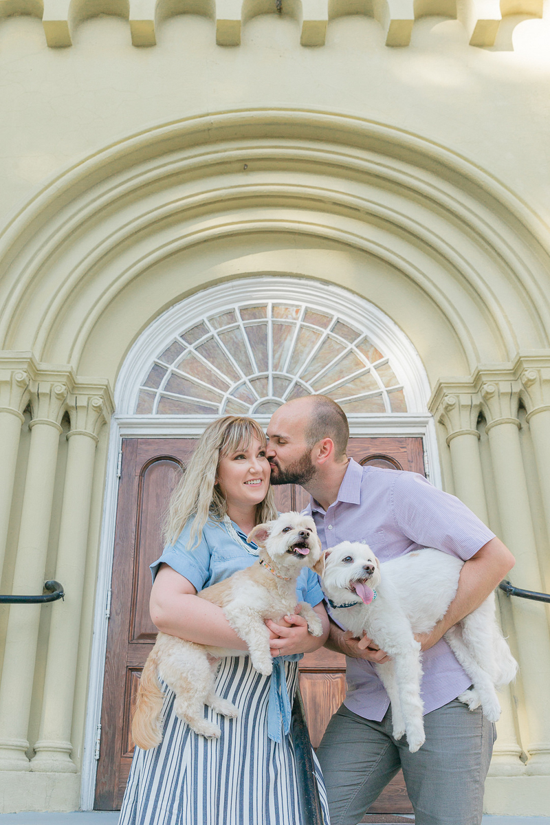 couple holding their dogs in front of arched doorway, Charleston Photo Art 